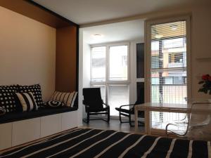 a living room with a couch and a desk and windows at Gorgeous central flat with garage in Ljubljana
