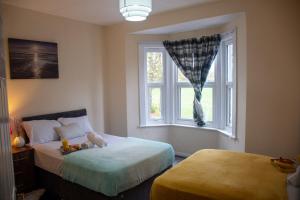 een slaapkamer met 2 bedden en een raam bij Royale Green View House- free parking, Wifi, Perfect for Contractors and Holiday in Northampton