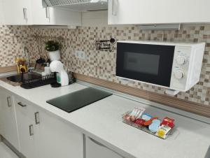 eine Küchentheke mit Mikrowelle und Spüle in der Unterkunft Estudio Torremolinos Centro by AVA Apartments Wifi y Smart TV in Torremolinos