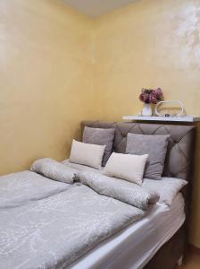 een bed met kussens in een kamer bij Centar view lux in Novi Sad