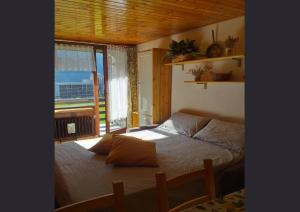ein Schlafzimmer mit einem Bett und einem großen Fenster in der Unterkunft Genepy Cervinia apartment Vda Vacanze in Vetta CIR 0252 in Breuil-Cervinia