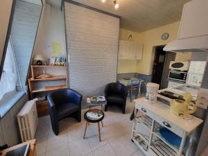 una cucina con due sedie e un tavolo in una stanza di Studiomer Résidence pleine mer a Saint-Pierre-en-Port