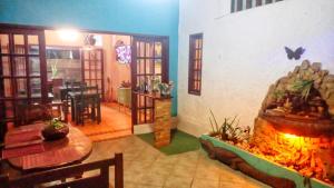 a living room with a fireplace and a dining room at Solo Buziano Guest House in Búzios