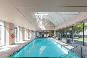 a large swimming pool in a building with windows at Sunset Beach Walk 2BD+2BA+1PRK Yaletown in Vancouver