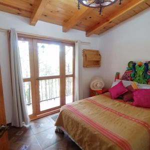 ein Schlafzimmer mit einem großen Bett und einem großen Fenster in der Unterkunft Cabaña D' Leon in Mazamitla