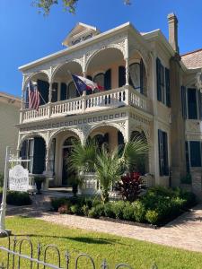 a house with two flags on the front of it at Coppersmith Inn Bed And Breakfast in Galveston