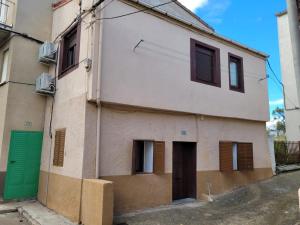 a building with a green door on a street at Casa Tía María in Navaluenga