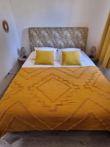 a large yellow bed with two yellow pillows on it at Joli 3 pièces à proximité des plages à Cagnes /mer in Cagnes-sur-Mer