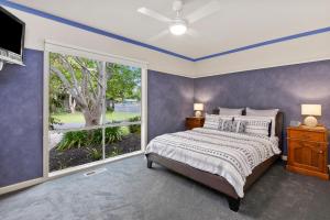 1 dormitorio con cama y ventana grande en SANDY ANN at Lonnie, en Point Lonsdale