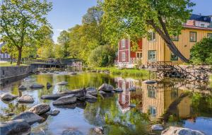 a river with rocks in front of a building at Nice Home In Norrtälje With Wifi in Norrtälje +16 photos