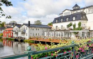 a group of buildings next to a river with flowers at Nice Home In Norrtlje With Wifi in Norrtälje