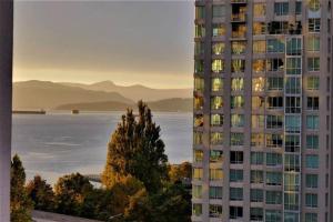 a tall apartment building with a view of the water at Sunset Beach Walk 2BD+2BA+1PRK Yaletown in Vancouver