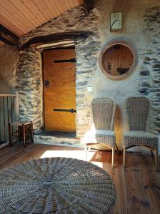 um quarto com duas cadeiras e uma porta em Gîte Sainte Croix en Jarez, Le Val des Equins em Sainte-Croix-en-Jarez