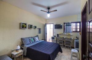 een slaapkamer met een bed en een keuken bij Casatemporadapero Moinho in Cabo Frio