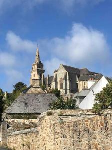 an old stone building with a church in the background at Logement indépendant,calme à 2 pas du centre ville in Lannion