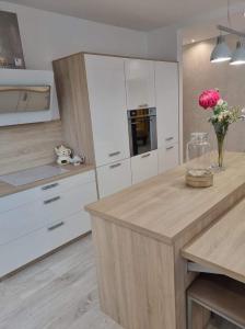 a kitchen with white cabinets and a vase of flowers at Joli 3 pièces à proximité des plages à Cagnes /mer in Cagnes-sur-Mer