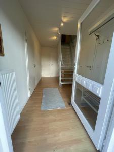 um quarto vazio com um corredor com uma escada em Ferienhaus Mühlengrund em Grundhof