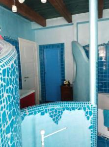 a room with blue tiled walls and a bed in a room at Affascinante Villino in Monsampolo del Tronto