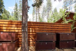 a wooden fence with boxes next to a tree at Evergreen Lodge at Yosemite in Groveland