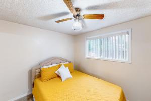 a bedroom with a yellow bed with a ceiling fan at Livin' the Dream in Springfield