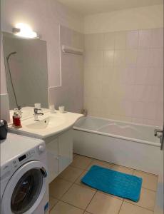 a bathroom with a washer and a sink and a washing machine at Magnifique T3 avec balcon vue montagne , plein centre et proche du lac in Gérardmer