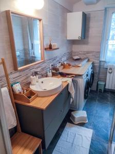 een badkamer met een wastafel en een wasmachine bij Appartamento incantevole con camino - EDOLO74 in Edolo