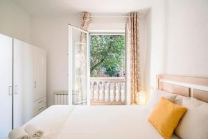 a bedroom with a white bed and a window at Tranquilo apartamento en Principe Pío/Pza de España FLOR in Madrid