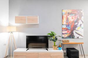 a living room with a tv and a painting on the wall at Tranquilo apartamento en Principe Pío/Pza de España FLOR in Madrid