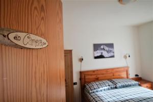 a bedroom with a bed and a sign on the wall at Cà Pizzo Scalino in Chiesa in Valmalenco