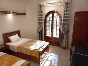 a bedroom with a bed and a window and a door at Mikhaila Guest House in Luxor