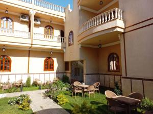 um pátio de um edifício com uma mesa e cadeiras em Mikhaila Guest House em Luxor