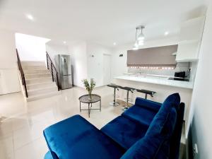 a living room with a blue couch and a kitchen at Oyster Guest House in Durban