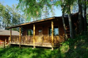 a log cabin in the woods with a porch at Mont du Lac Resort in Carlton