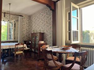 a dining room with a table and chairs and windows at Villa Verde in Camaiore +20 photos