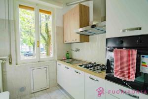eine Küche mit weißen Schränken und einem Herd mit Backofen in der Unterkunft FuoriPorta Affitti Brevi - Residence Dacci in Parma