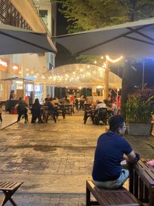 a man sitting on a bench in front of a patio at 6 PAX 1 BEDROOM near USM SPICE ARENA PANTAI SPECIALIST AIRPORT in Bayan Lepas +9 photos
