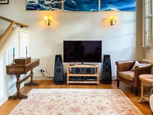 a living room with a flat screen tv and speakers at The Chapel in Owslebury