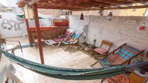 eine Hängematte auf einer Terrasse mit Stühlen und einem Tisch in der Unterkunft Beraja Family Hostel in Lima