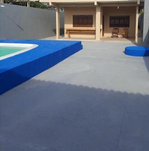 a patio with a blue curb and a bench at L & C - Casa por Temporada in Macapá