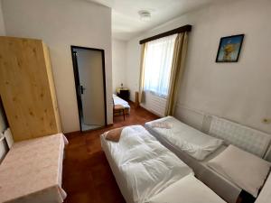 1 dormitorio con cama blanca y espejo en Penzión Jazmín, en Prašice