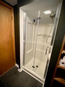 a shower with a glass door in a bathroom at Cabin close to Lake Willoughby and ski areas in Barton