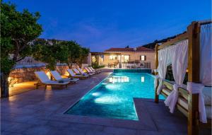 einen Pool mit Liegestühlen neben einer Villa in der Unterkunft Nice Home In Gruda With Outdoor Swimming Pool in Gruda