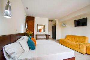1 dormitorio con 1 cama grande y 1 sofá en Hotel Monarca Armenia, en Armenia