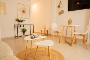 un soggiorno con tavolo e sedie bianche di GoToSeville ALTAIR SUITES a Siviglia