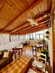 una sala de estar con techos de madera, mesas y sillas en Atenea Luxury Suites, en Agrigento