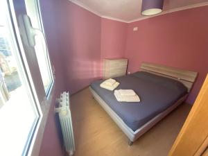 a small bedroom with a bed and a window at Casa do Adro in Lavacolhos