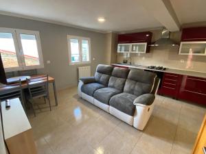 a living room with a couch and a kitchen at Casa do Adro in Lavacolhos +8 photos