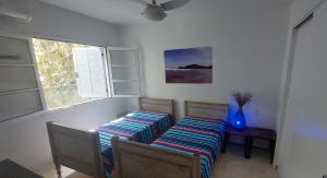 two beds sitting in a room with a window at Casa sossegada ao lado da natureza e do mar in São Sebastião