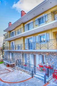 a building with red tables and chairs in front of it at "Mykines" Apartment of Levidi Arcadian Apartments in Levidi