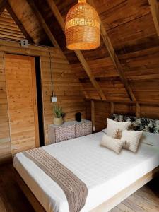 1 dormitorio con 1 cama grande en una habitación de madera en Glamping bali, en Sopetrán